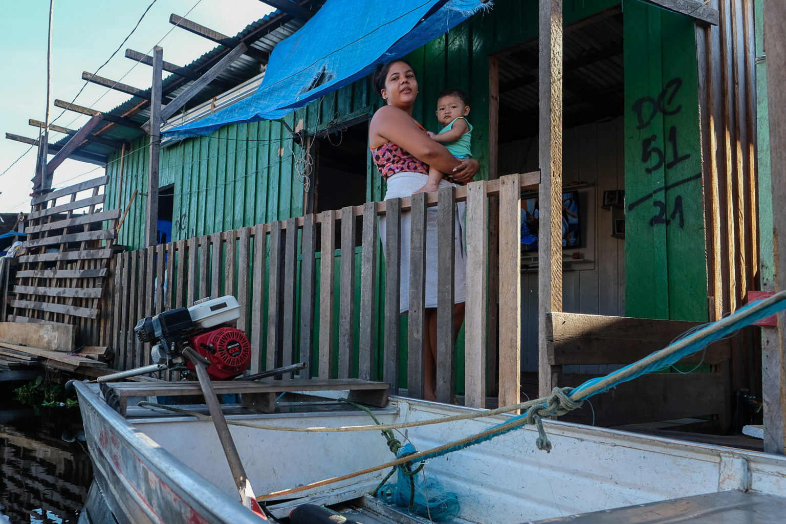 Pâmela Gomes com o filho em sua casa no bairro do Educandos, em Manaus: sofrimento com as cheias recorrentes desde o ano de 2012 (Foto: Alberto César Araújo/Amazônia Real)