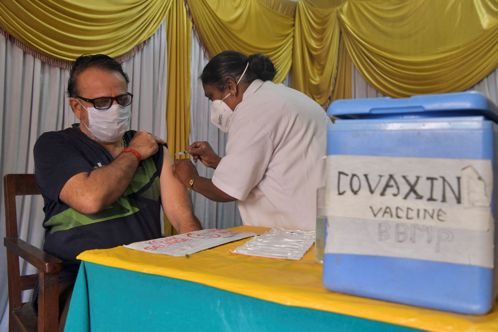 Profissional de saúde aplica Covaxin em Bangalore, na Índia: imunização no país começou antes mesmo de testes terem sido aprovados (Foto: Manjunath Kiran / AFP - 09/06/2021)