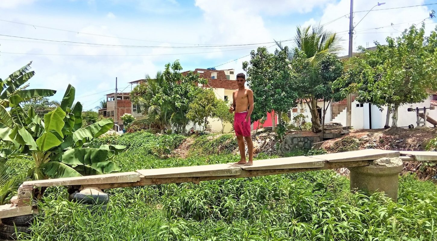 Israel em uma ponte improvisada sobre o Rio Beberibe, na divisa entre Recife e Olinda | Foto de Victor Moura