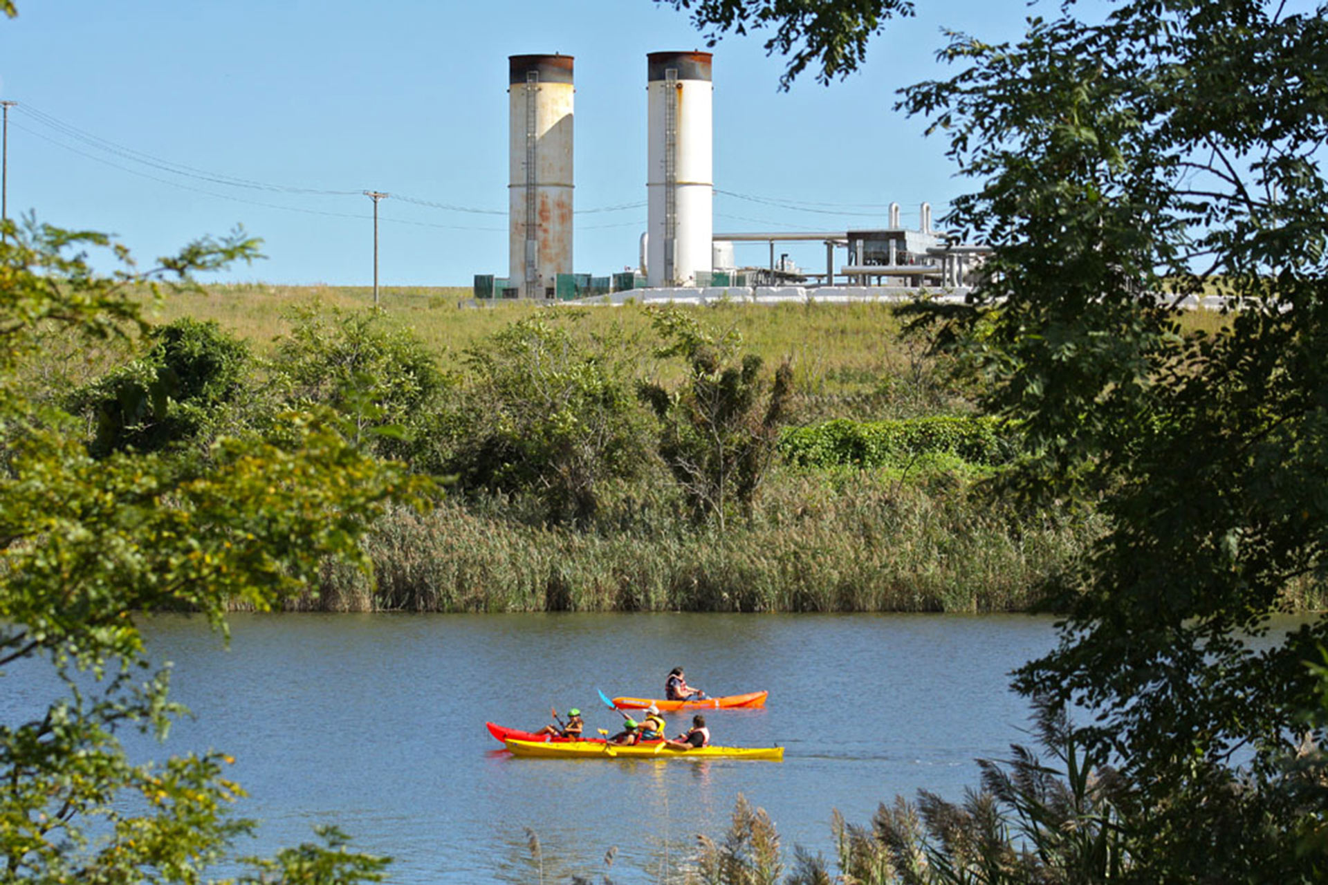 Visitantes passeiam de caiaque no Parque Fresh Kills com planta de purificação de gás metano da decomposição do lixo no antigo aterro sanitário: lixo enterrado serve para produzir energia para 20 mil casas (Foto: Divulgação)