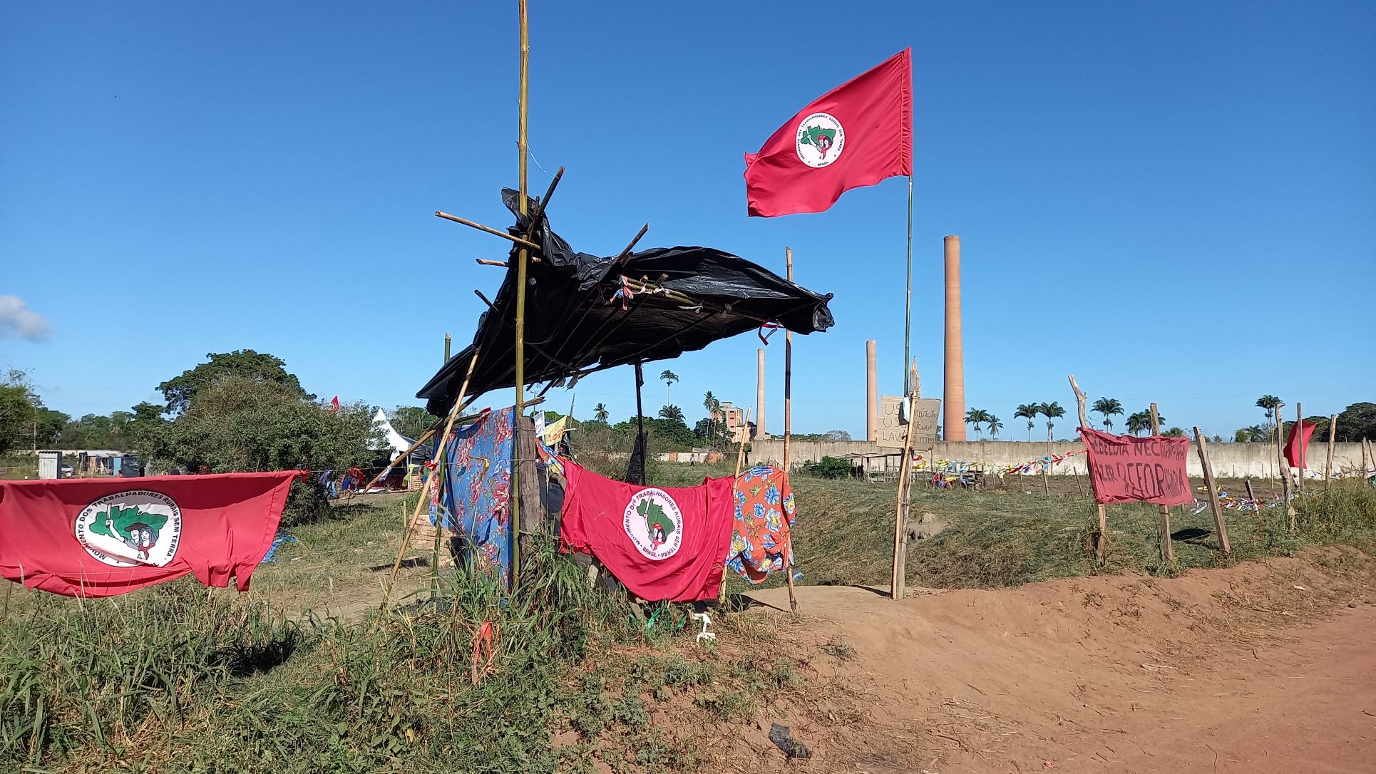 Bandeiras do MST na entrada do acampamento em Campos: luta por ocupação e destinação das fazendas para a reforma agrária (Foto: Vivi Fernandes de Lima)