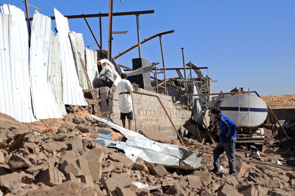 Iemenitas em área destruída por ataque saudita em Sanaa, capital do país: sete anos de guerra entre exército oficial e forças rebeldes (Foto: Mohamed Huwais / AFP - 05/12/2021)