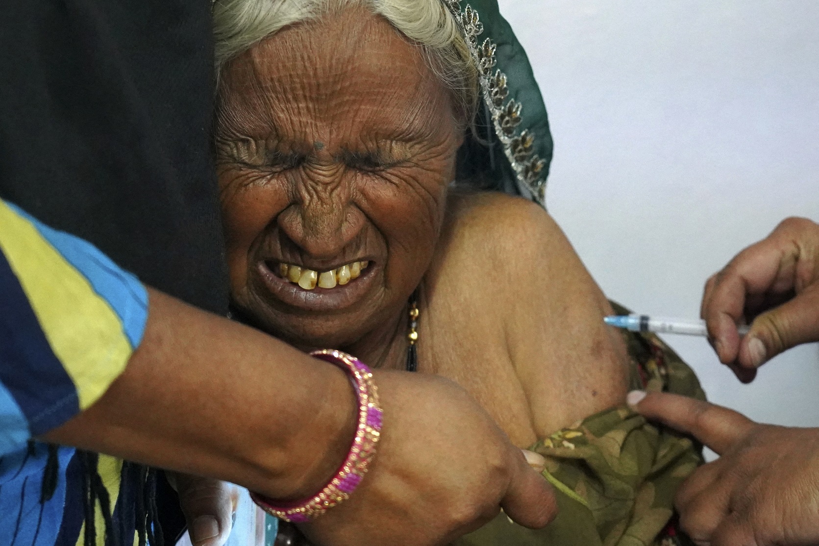 Nos arredores de Ajmer, na Índia, idosa recebe a sua dose da vacina contra a covid-19. Foto Himanshu Sharma/AFP. Março/2021