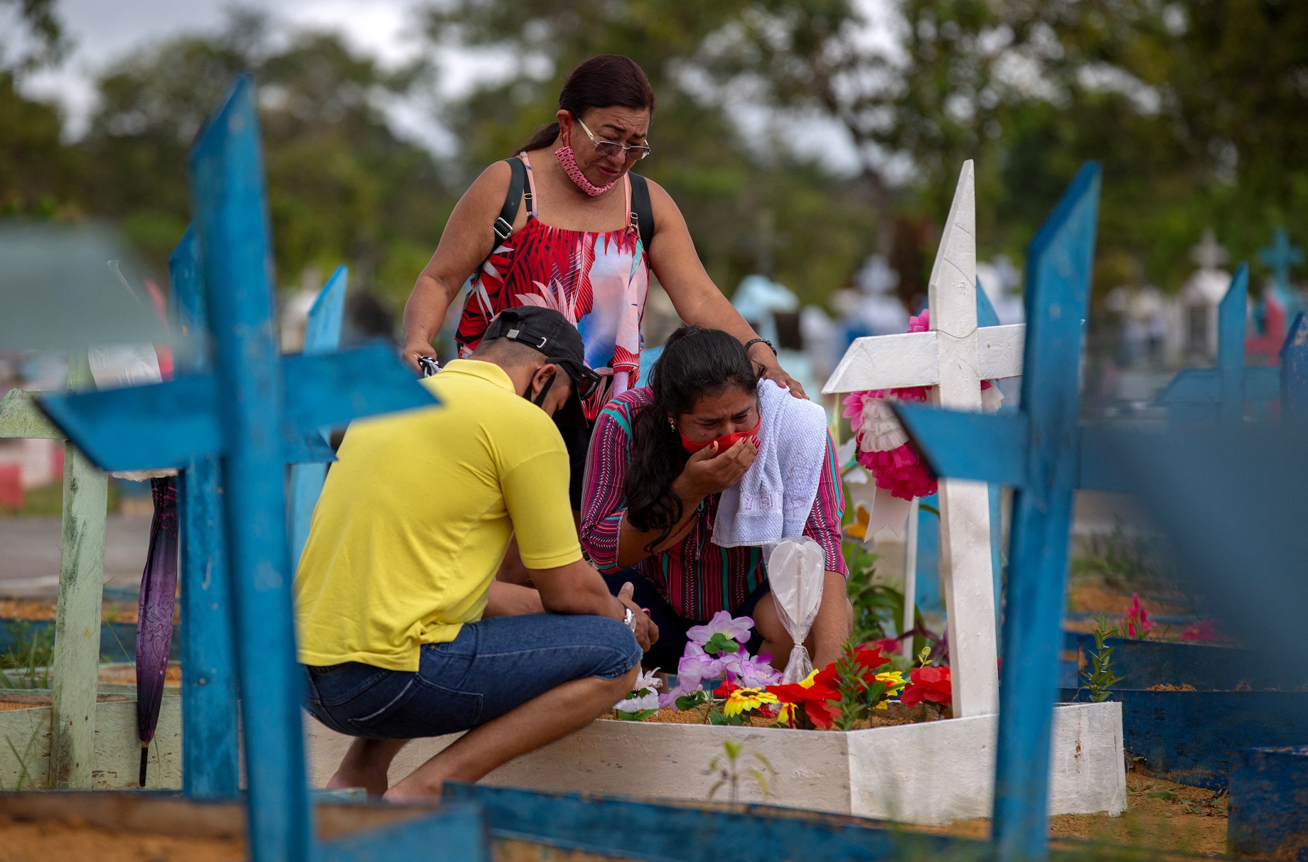Familiares visitam um parente morto pela covid-19 no cemitério de Nossa Senhora Aparecida, em Manaus. Foto Michael Dantas/AFP. Maio/2021