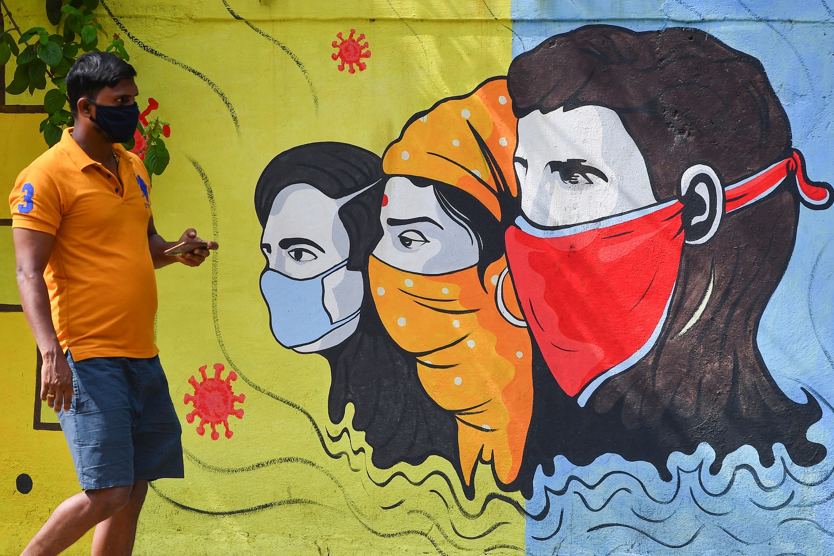 Em Mumbai, um grafite ajuda a conscientizar as pessoas sobre a importância do uso de máscaras. A Índia é o segundo país em número acumulado de casos de covid-19. Foto Indranil Mukherjee/AFP