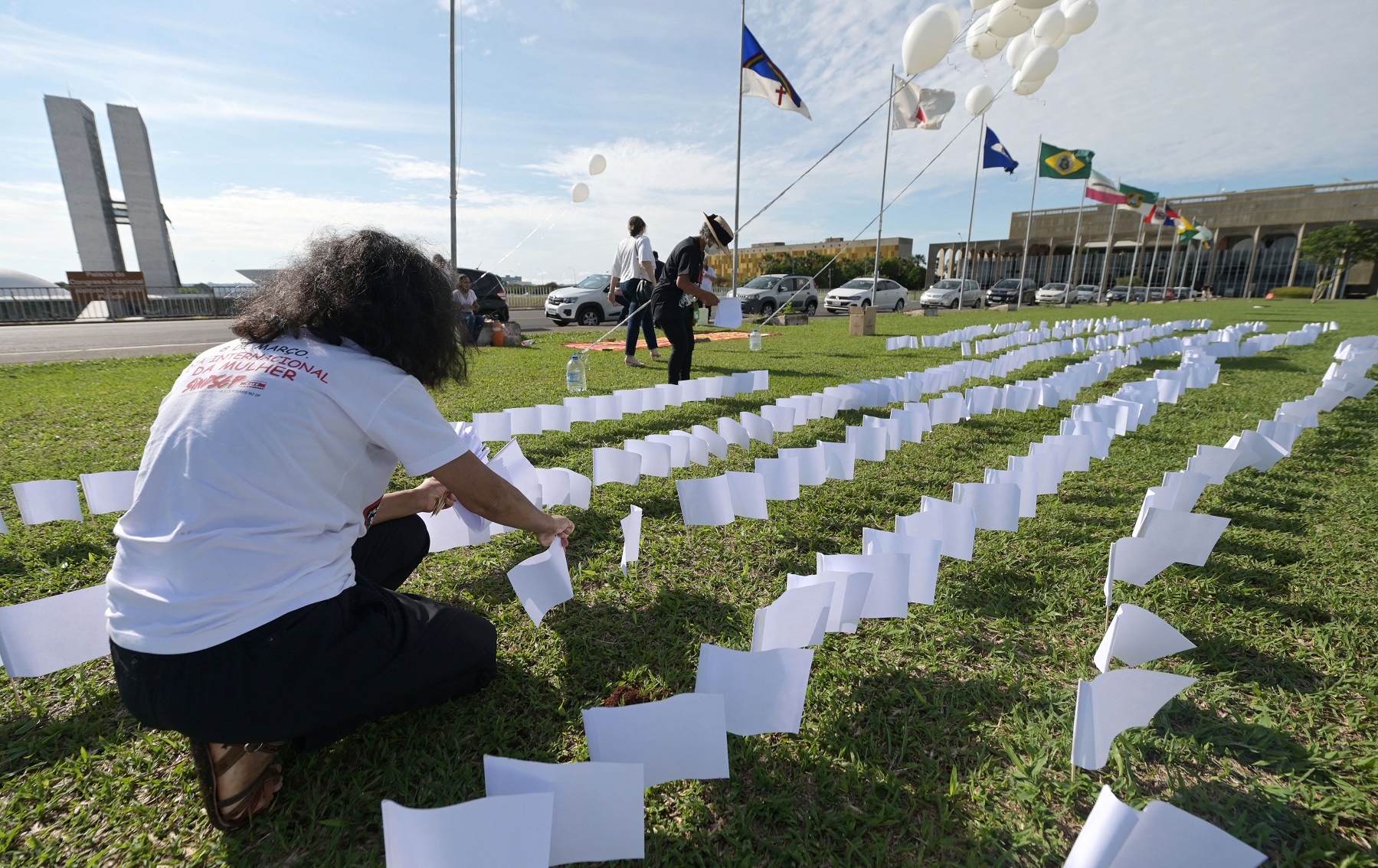 Membros da Associação de Vítimas e Familiares da covid-19 colocam 600 bandeiras brancas em frente ao Congresso Nacional, em Brasília, em homenagem aos 600 mil mortos vítimas da doença. Foto Evaristo Sa/AFP. Outubro/2021