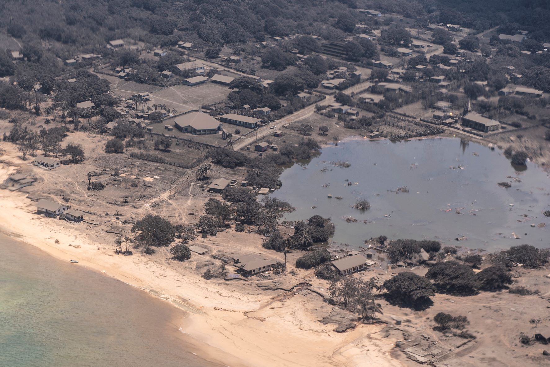 Casas e árvores cobertas pelas cinzas do vulcão na ilha de Nomuka, no arquipélago de Tonga: erupção mostra vulnerabilidade de sistema global de comunicações (Foto: Força de Defesa da Nova Zelândia / AFP)