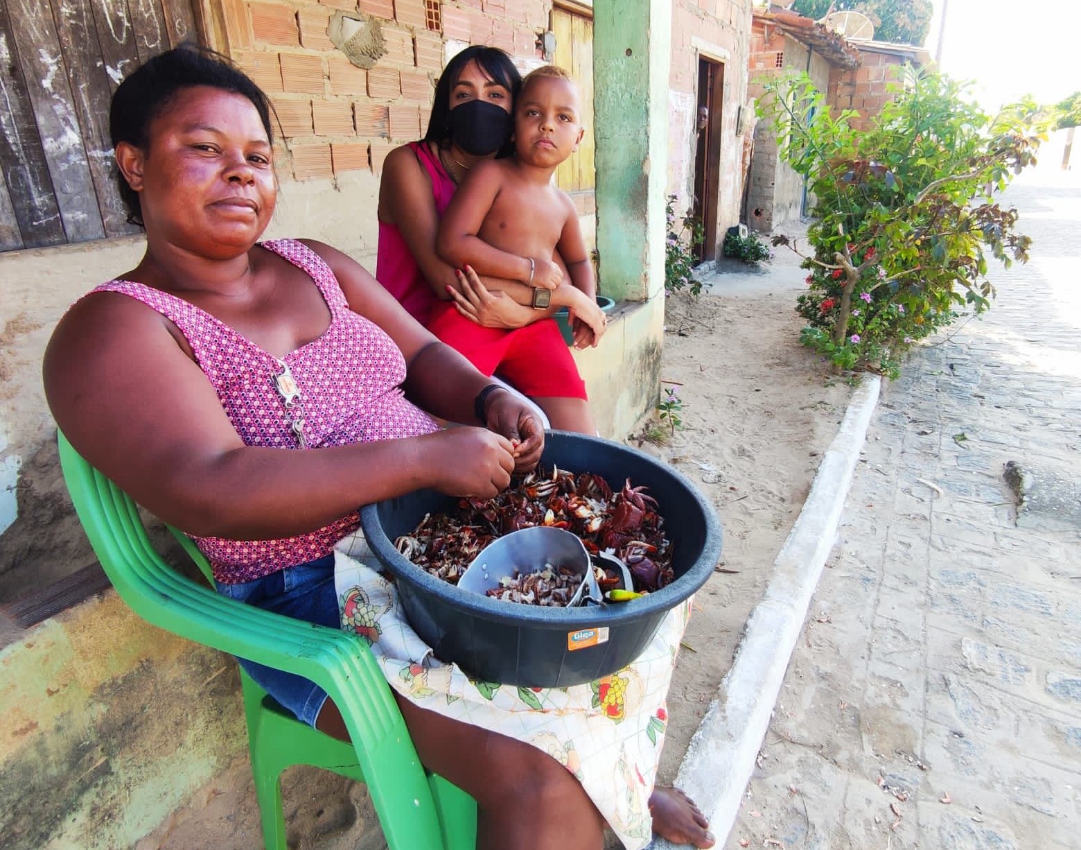 Ananda (de máscara) com uma marisqueira e seu filho na comunidade da preguiça: manejo sustentável e cuidados com a saúde (Foto: Arquivo Pessoal)