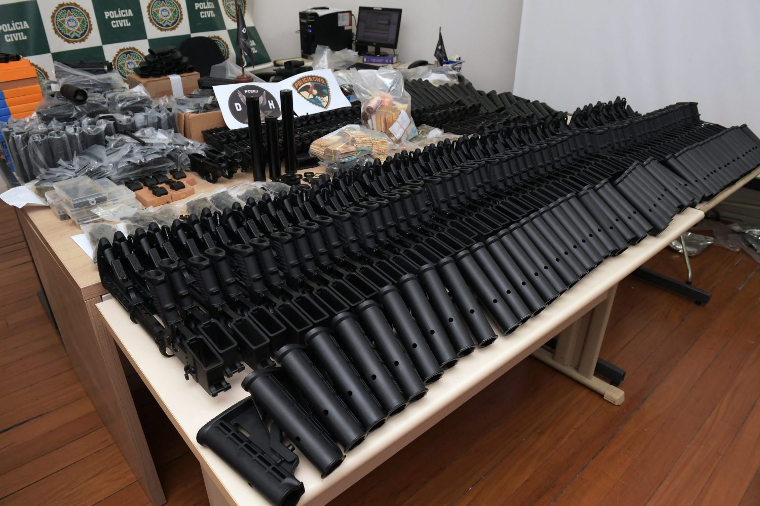 Armas automáticas, dinheiro e outros equipamentos apreendidos na casa de um amigo do policial militar Ronnie Lessa, preso pelo assassinato da vereadora Marielle Franco. Foto Carl de Souza/AFP