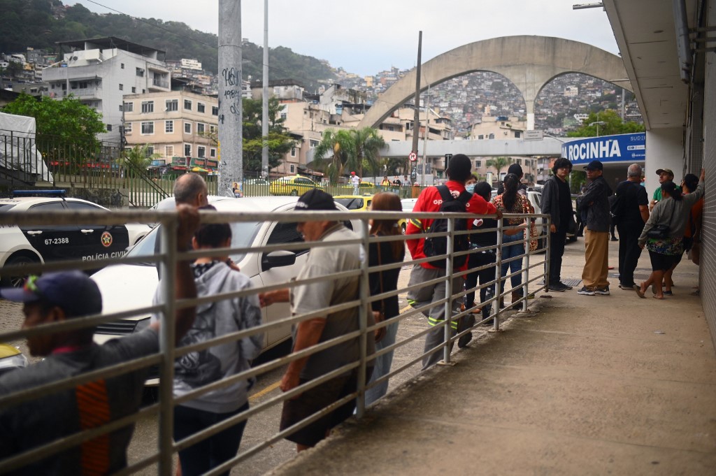 Fila de votação em frente à Rocinha, no Rio: dia tranquilo, com seções eleitorais lotadas mas em convivência pacífica. Foto André Borges/AFP