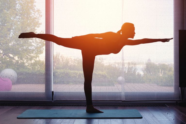 Mulher faz yoga ao pôr do sol: para pesquisadoras, indústria do bem-estar gerencia agenda diária das mulheres com "rotinas de cuidados com a pele, desafios de 30 dias, meditações, velas acesas, ioga e água com limão" (Foto: Sakkmesterke / AAT / Science Photo Library / AFP - 15/12/2021)