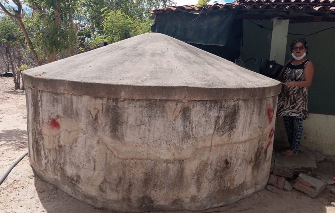 A agricultora Zélia, presidente da associação comunitária, com a cisterna: água para consumo e para produção de alimentos (Foto: Arquivo Pessoal)