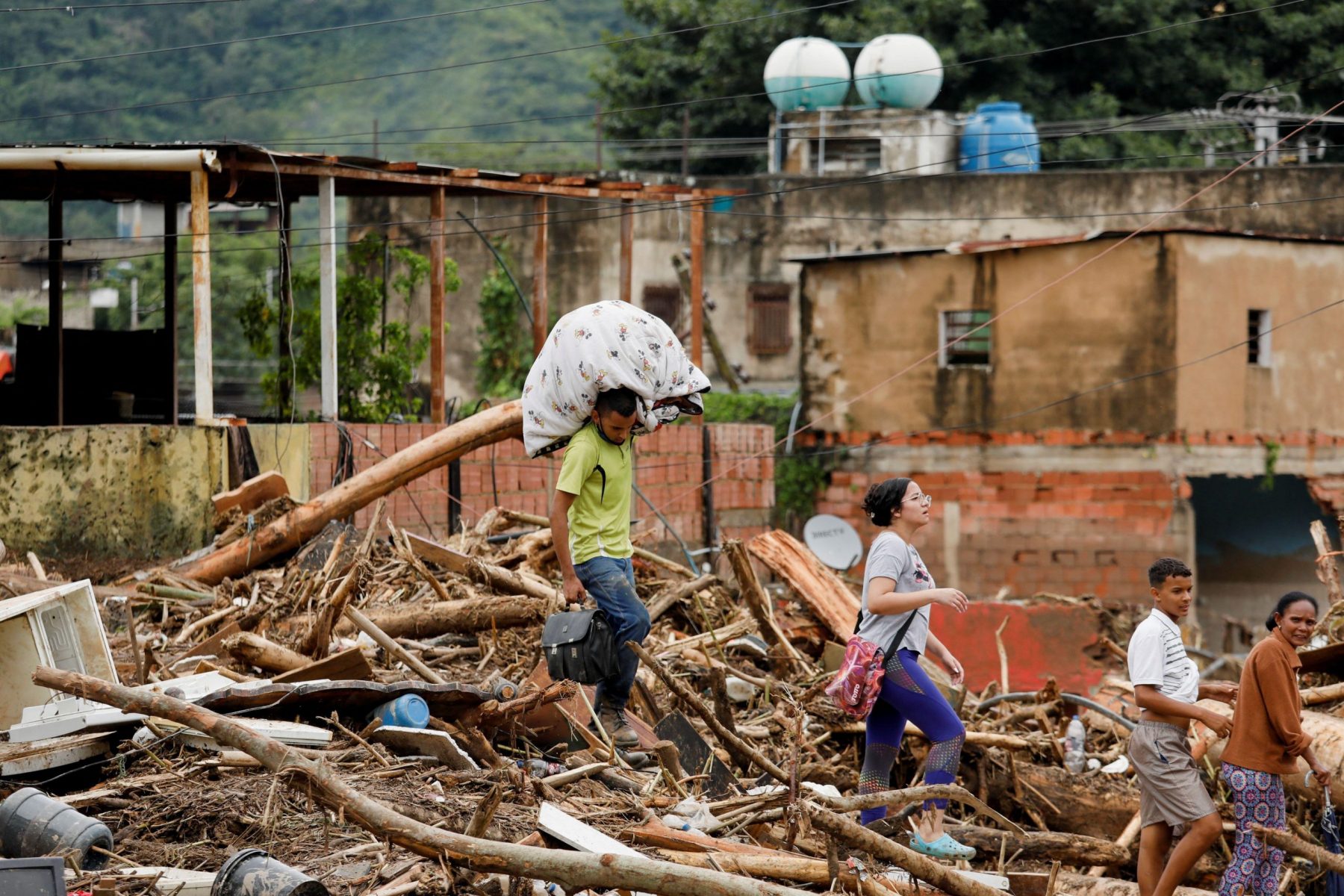 Foto Leonardo Fernandez Viloria / Alamy Homem carrega seus pertences após inundações causadas por fortes chuvas em Las Tejerias, Venezuela, em outubro de 2022. A América Latina está exposta a vários riscos, desde terremotos a inundações e secas. Foto Leonardo Fernandez Viloria / Alamy