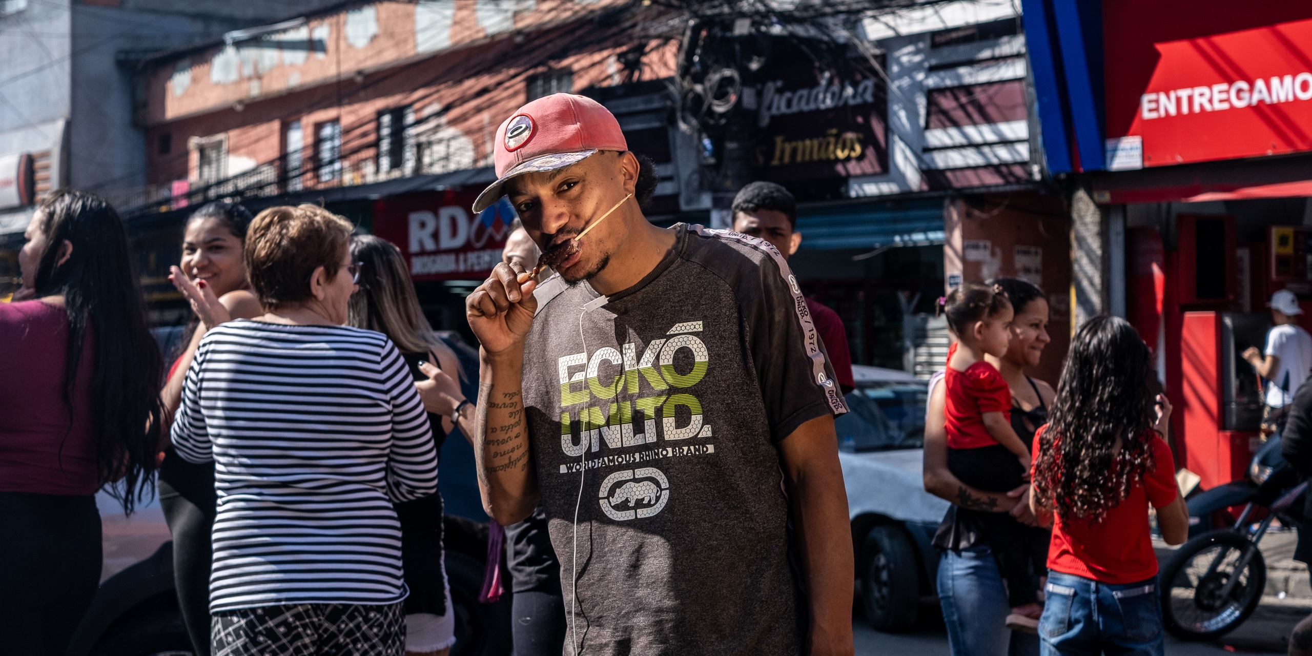 Cleiton Araújo, pintor de casas, devora um espetinho de carne: "nunca pensei em cortar". Foto Dan Agostini/Diálogo Chino