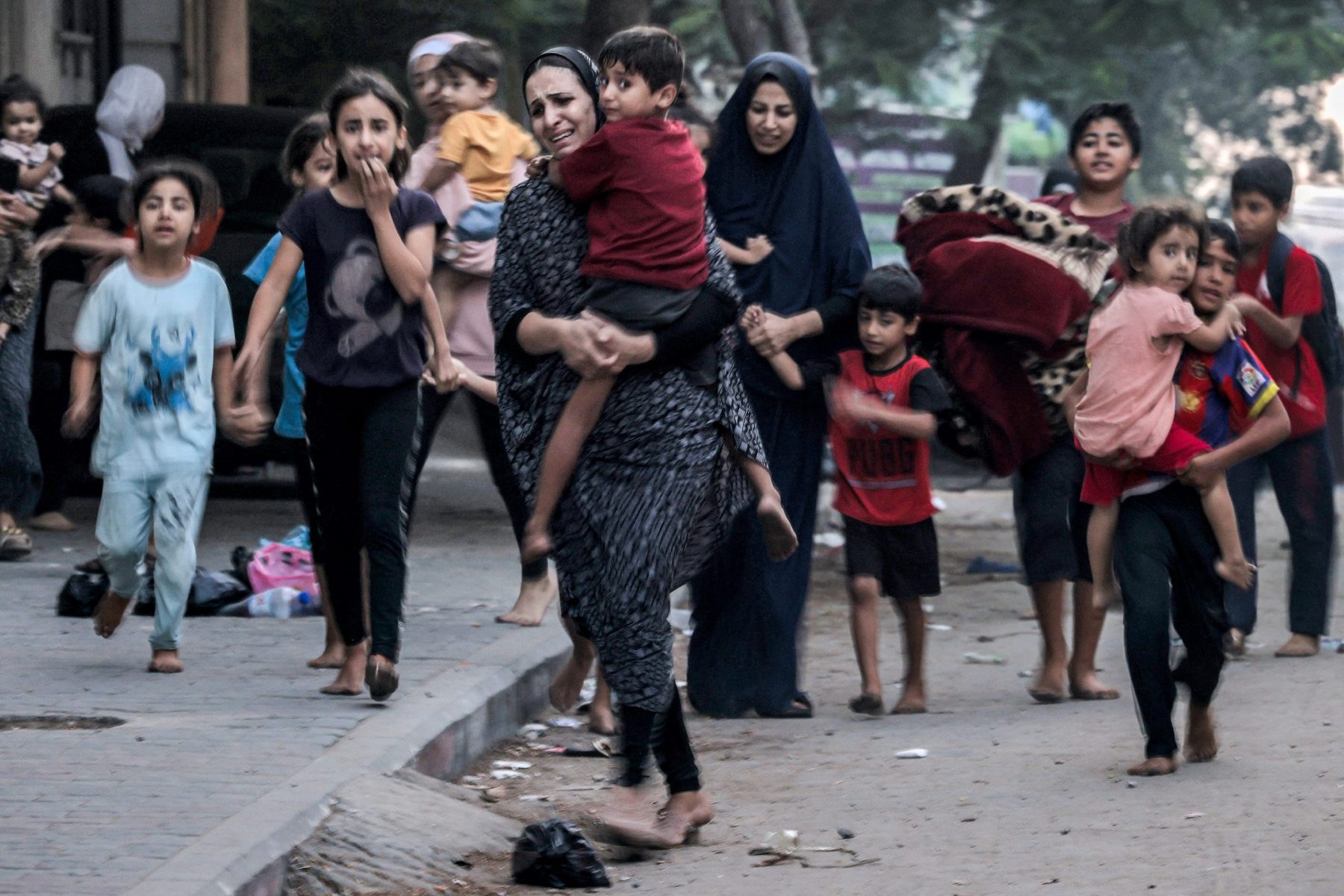 Mulheres e crianças palestinas fogem de bombardeio israelense na Faixa de Gaza: como seguir vivendo num mundo com guerras e conflitos simultâneos, sem paz no horizonte? (Foto: Mohammed Abed / AFP - 11/10/2023)