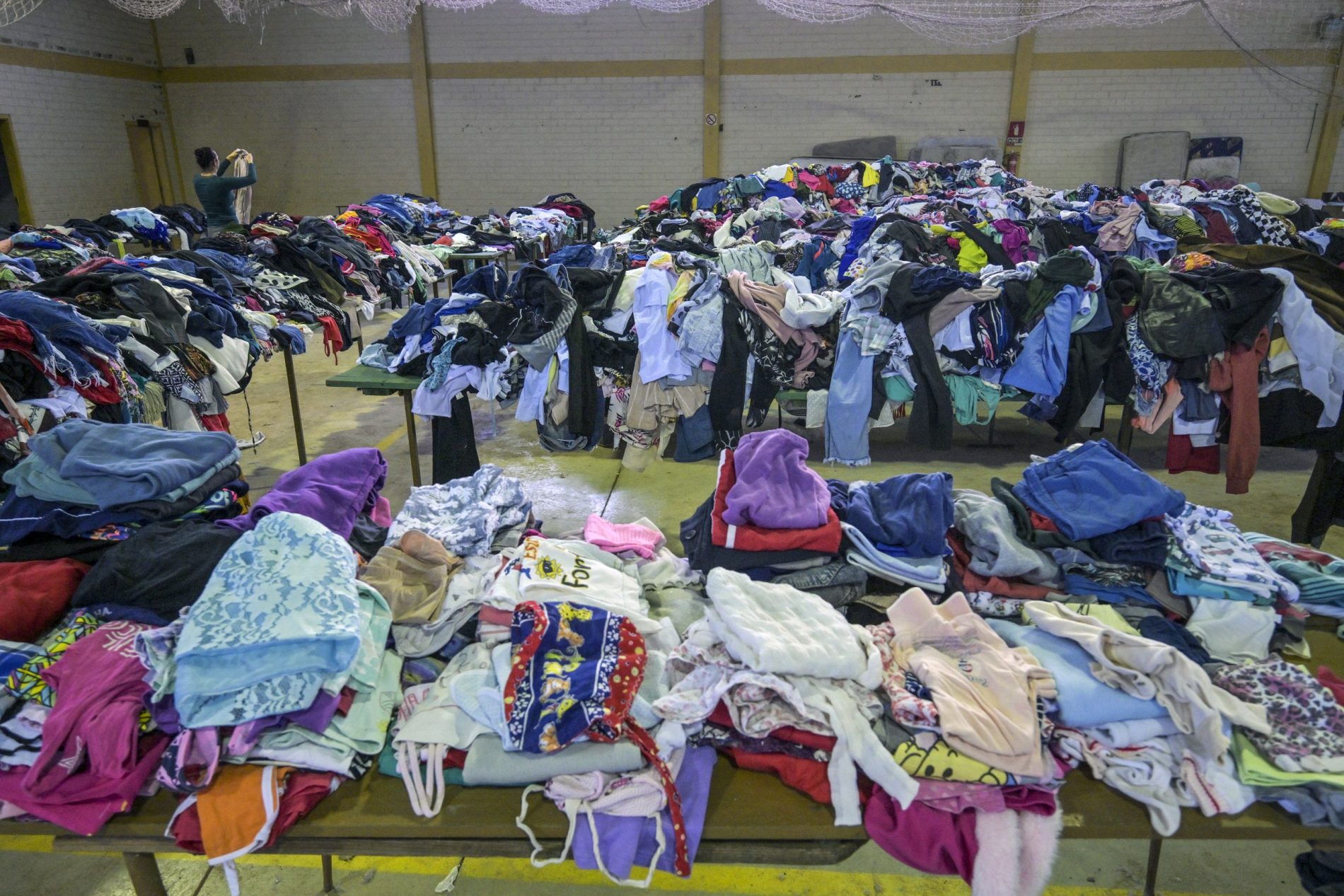 Roupas e calçados doados são separadas em um ginásio em Marques de Souza, no Rio Grande do Sul. Mais de 600 mil pessoas foram deslocadas pelas fortes chuvas, enchentes e deslizamentos de terra que devastaram o sul do país. Foto Nelson Almeida/AFP