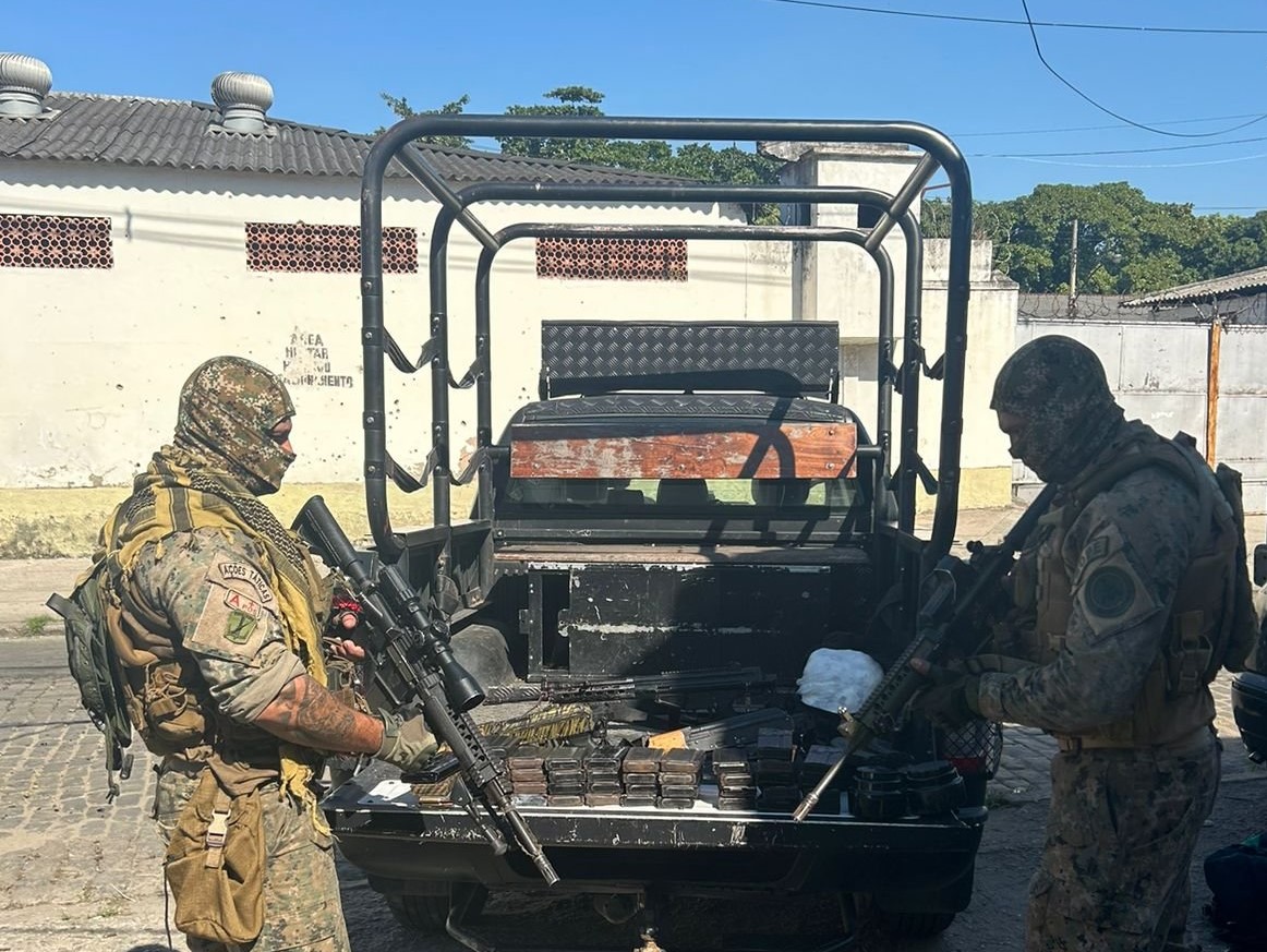 Policiais posam com armas e drogas apreendidas na Maré: permanência da lógica de combate, de morte e a normalização da violência (Foto: Divulgação / PMERJ)