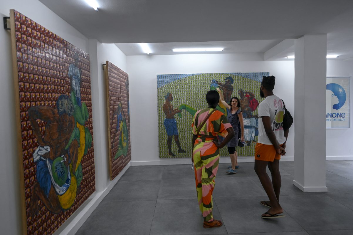 Foto Mauro Pimentel/AFP Visitantes apreciam as pinturas do artista Maxwell Alexandre na galeria fundada pelo artista, na favela da Rocinha. Foto Mauro Pimentel/AFP