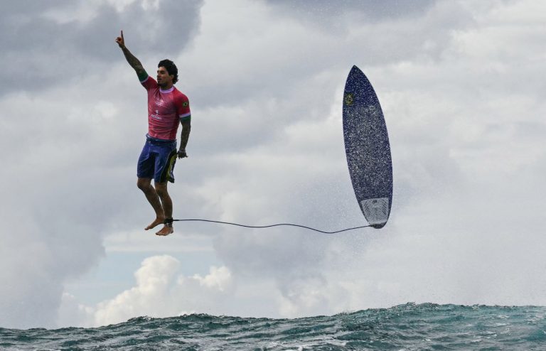 O voo do brasileiro Medina na disputa do surfe dos Jogos de Paris 2024: condições do fundo do mar no Taiti tornam na praia olímpica únicas e desafiadoras, permitindo manobras espetaculares (Foto: Jerome Brouillet / AFP)