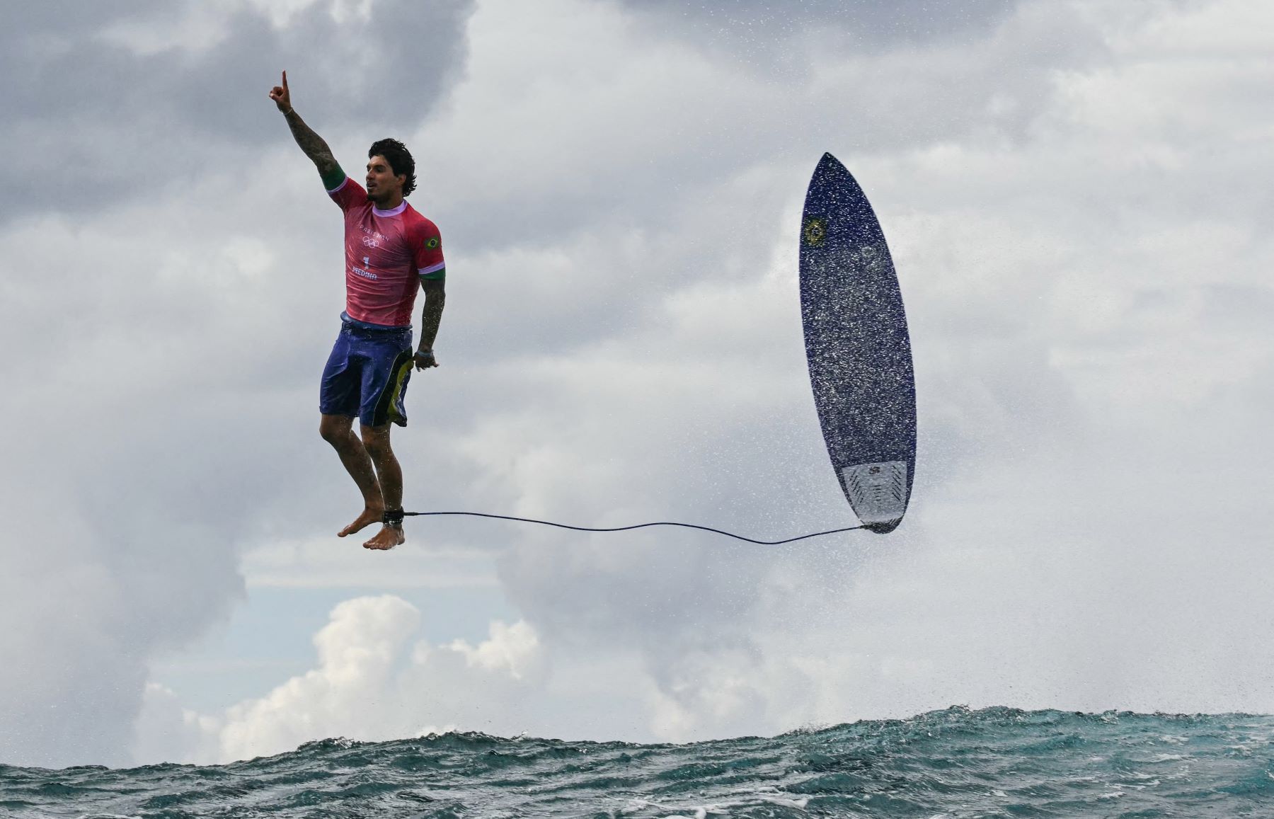 O voo do brasileiro Medina na disputa do surfe dos Jogos de Paris 2024: condições do fundo do mar no Taiti tornam na praia olímpica únicas e desafiadoras, permitindo manobras espetaculares (Foto: Jerome Brouillet / AFP)
