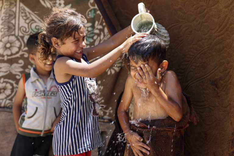 Crianças se refrescam em meio as altas temperaturas e os cortes de energia na cidade de Gaza, na Palestina. O ano de 2023 está sendo o mais quente dos últimos 12 mil anos. Foto Mohammed Abed/AFP