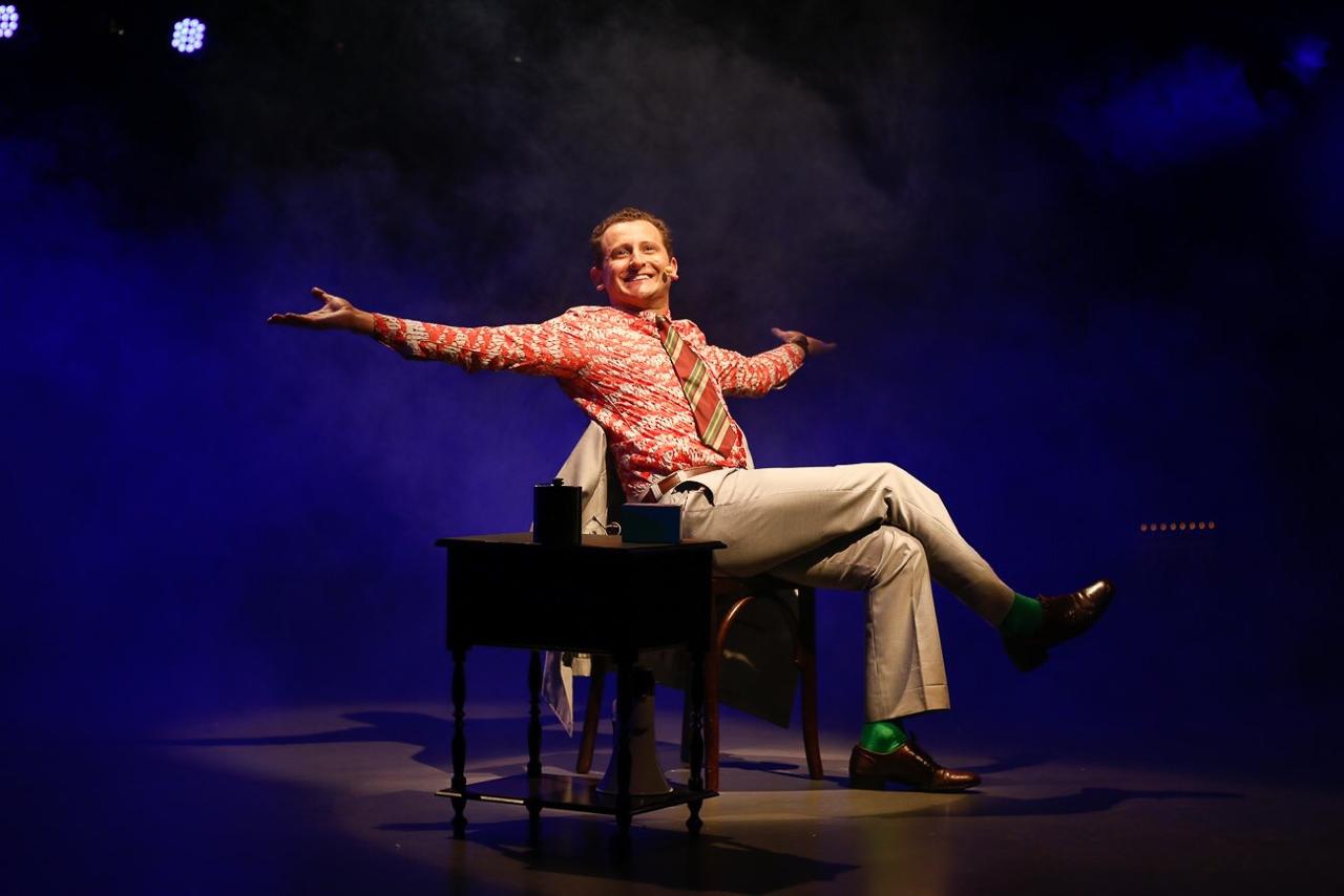 Ed Moraes no teatro como Harvey Mills, ativista e primeiro político assumidamente gay eleito nos EUA: crime em 1970 ligado ao Brasil atual e seu ranking mundial de assassinatos da comunidade LGBTQIA+ (Foto: Amanda Clemente / Divulgação)