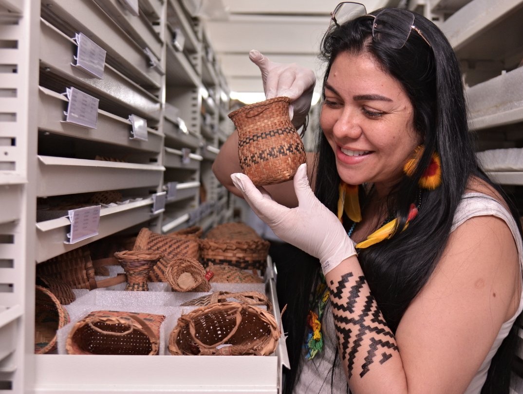 A advogada Fernanda Kaingang, primeira indígena a dirigir o Museu do Ínndio desde a fundação em 1953, examina peças do acervo: exposições e eventos em parceria (Foto: Divulgação/Funai)