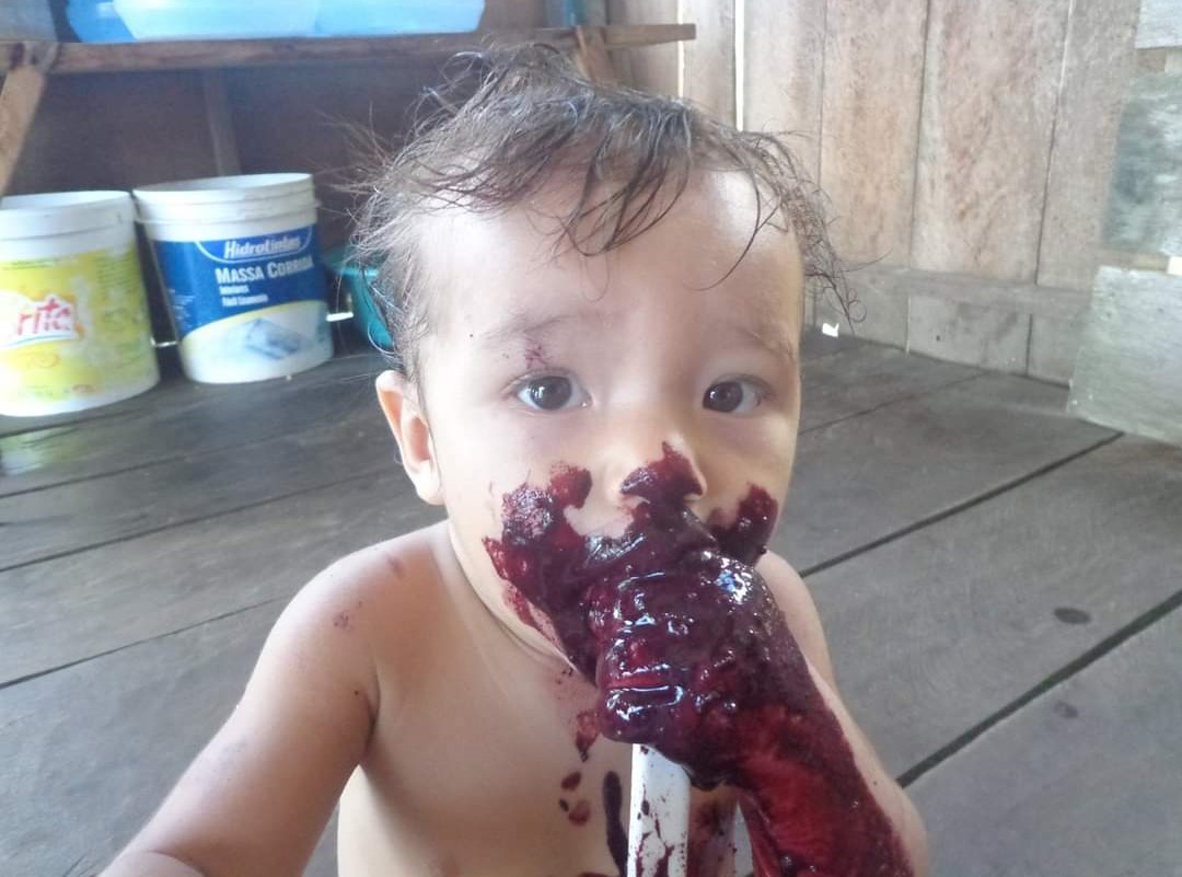 Sobrinho do ribeirinho Paulo se lambuza de açaí: pelos saberes amazônicos, fruto do açaí representa as lágrimas de uma mulher tupi que chorou ao ter filho sacrificado (Foto: Paulo Araújo)