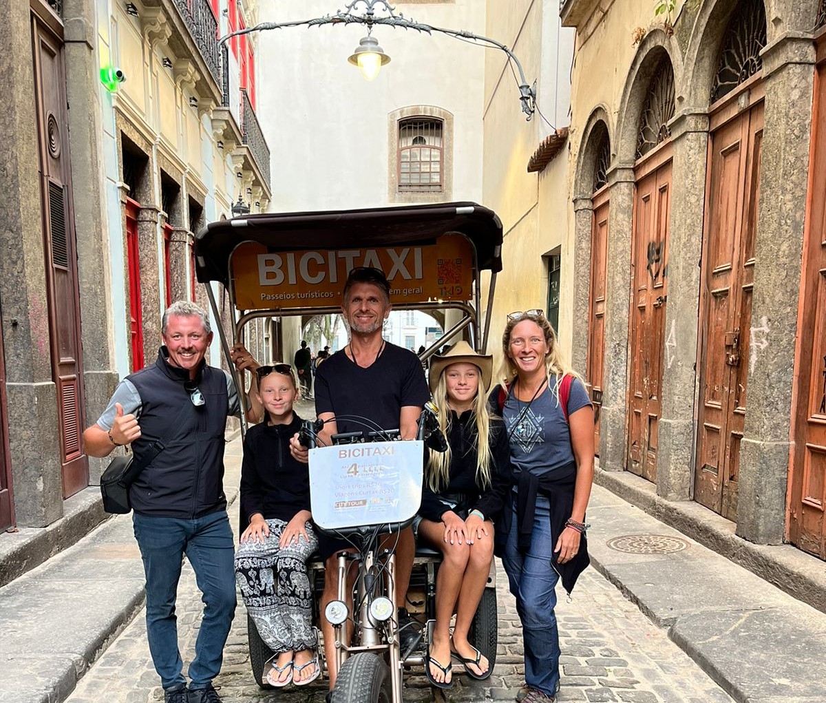 Michael Linke com passageiros de seu bicitáxi no Centro do Rio: passeios para turistas sem emissão de carbono (Foto: Divulgação)