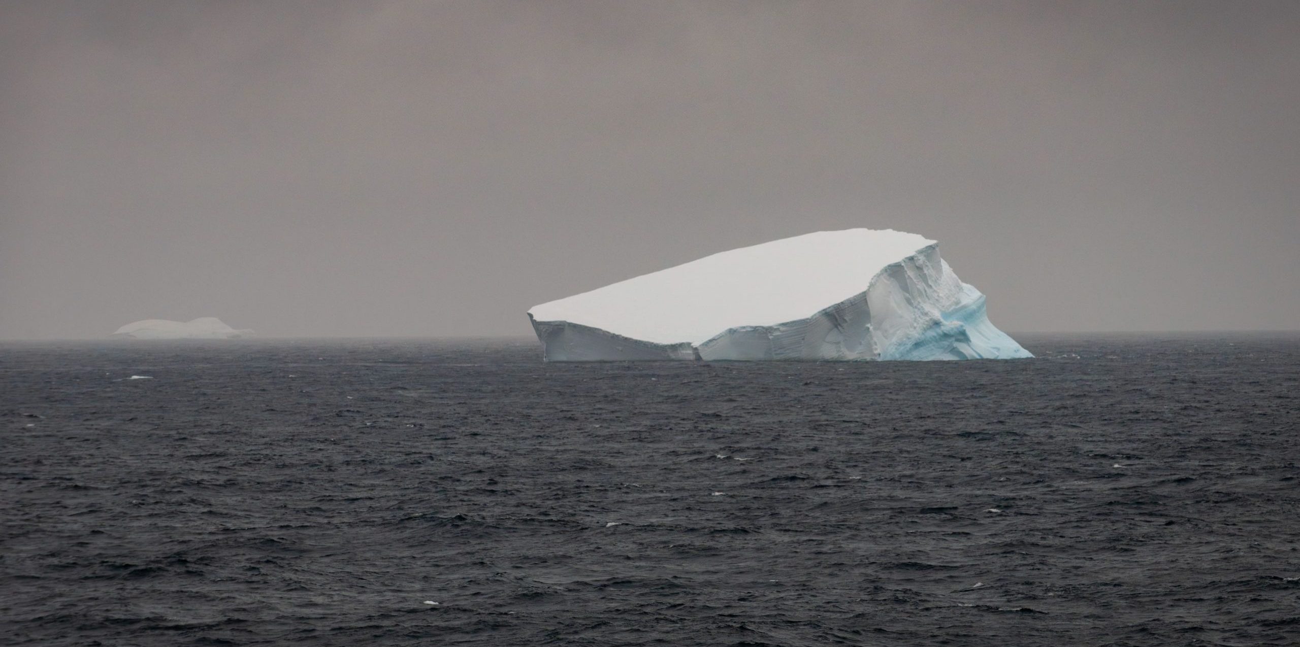 Foto colorida de placa de gelo derretendo em oceano na Antártica