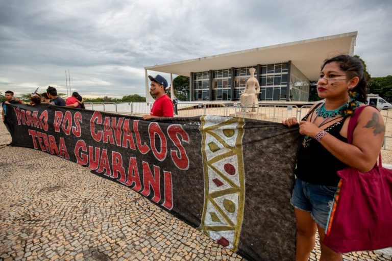 Foto colorida de líderes da etnia Guarani da Terra Indígena Morro dos Cavalos participam de ato em Brasília: Senado aprova projeto que desestrutura demarcação (Foto: Tiago Miotto / Cimi)