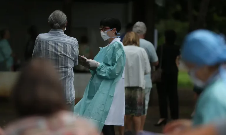 Foto colorida de fila de pessoas idosas para receber vacinas contra Influenza; envelhecimento da população desafia sistema de saúde
