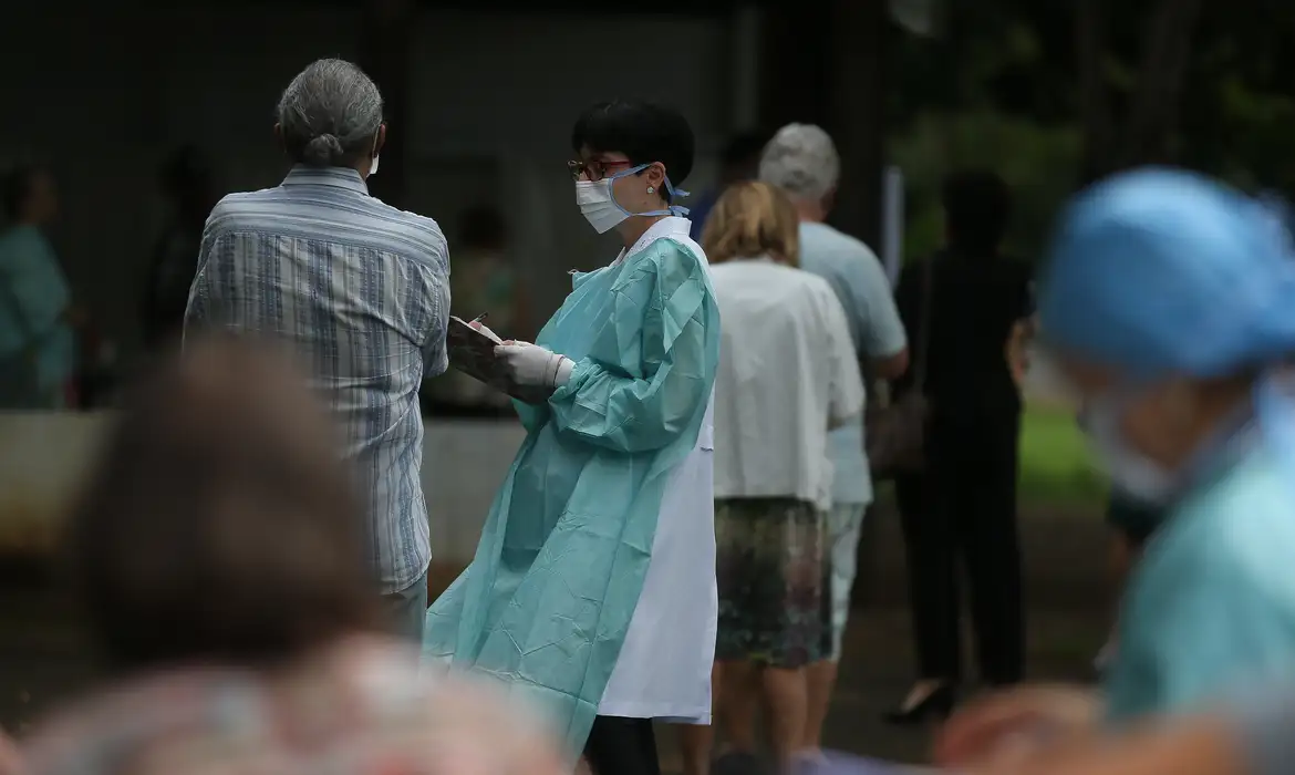 Foto colorida de fila de pessoas idosas para receber vacinas contra Influenza; envelhecimento da população desafia sistema de saúde