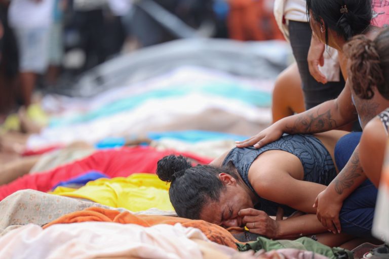 Mulher chora ao lado de corpos enfileirados em praça da Zona Norte do Rio: número de mortos na chacina mais letal da história do estado passa de 100 (Foto: Tomaz Silva / Agência Brasil)