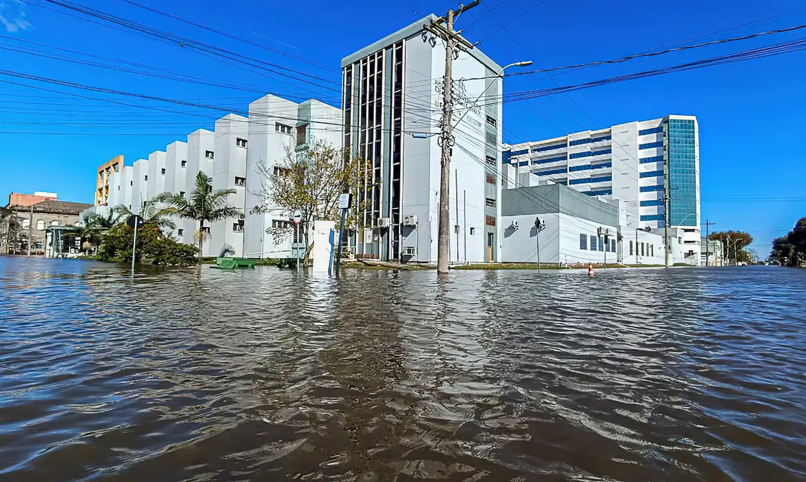 Foto colorida do Hospital Universidade Dr. Miguel Riet Corrêa Jr, da Universidade Federal de Rio Grande, cercado pelas águas da Lagoa dos Patos durante enchente em 2024