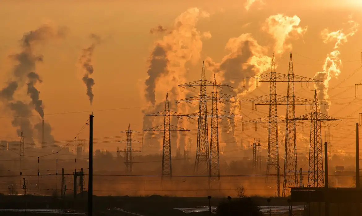 Foto colorida que mostra fumaça de usinas de combustíveis fósseis, principal causa do aquecimento global e da crise climática
