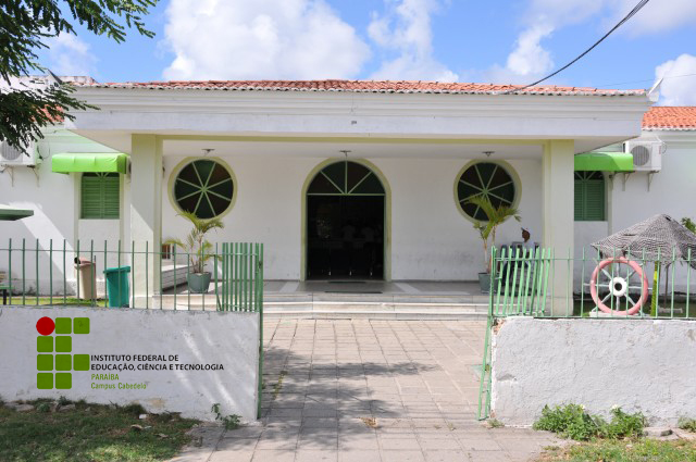 Foto colorida da fachada do Instituto Federal da Paraíba (IFPB) - Campus Capedelo Centro. O prédio é branco com detalhes verdes.